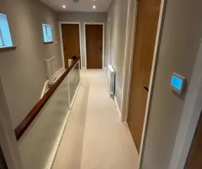 Renovated landing with glass balustrade and oak doors