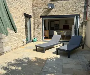 Stone patio laid outside bi-fold doors on a cottage extension